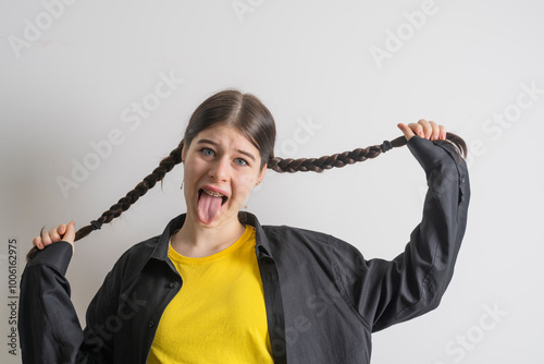 Teenager girl with braces having fun at home, showing self-love and individuality.