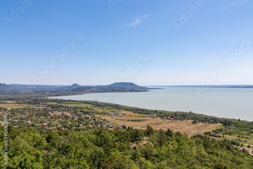 Panoramic aerial view of Balaton lake seen from observation tower Padkui Kilato in Balatongyorok, Hungary, Europe. Small villages along the lakeshore surrounded by rolling hills and lush greenery photo