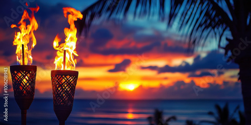 Hawaii luau party Maui fire tiki torches with open flames burning at sunset sky clouds at night