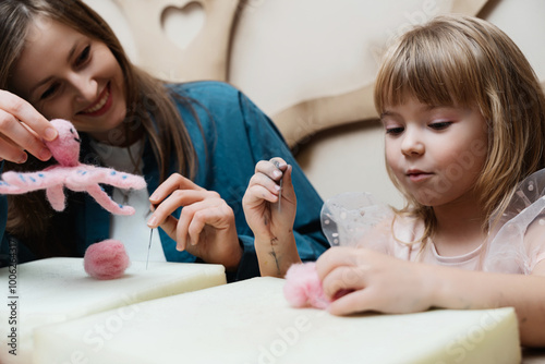 Mother and daughter crafting a pink octopus at a creative workshop together photo