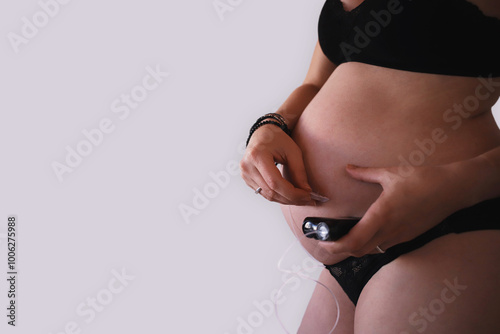 Pregnant woman removing infusion set from belly while holding insulin pump