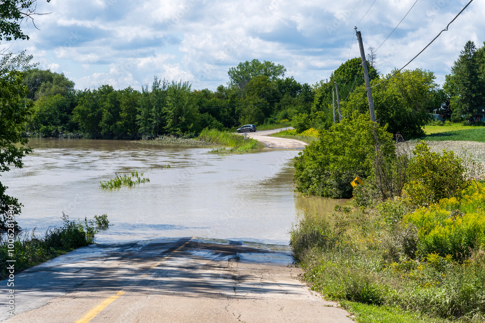 Fototapeta premium A flodded road in a Quebec rural region