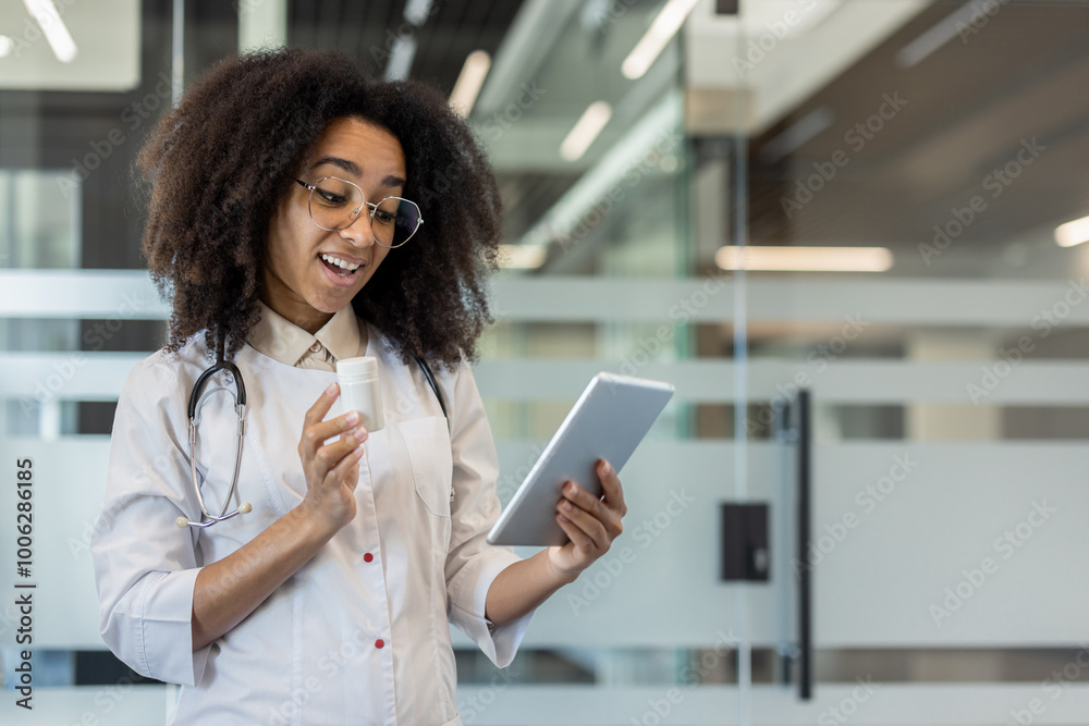Photo of a young African-American female doctor in a hospital room, praying on a video call on a tablet, holding a jar of pills in her hand and showing the camera Photo of a young African-American female doctor in a hospital room, praying on a video call on a tablet, holding a jar of pills in her hand and showing the camera