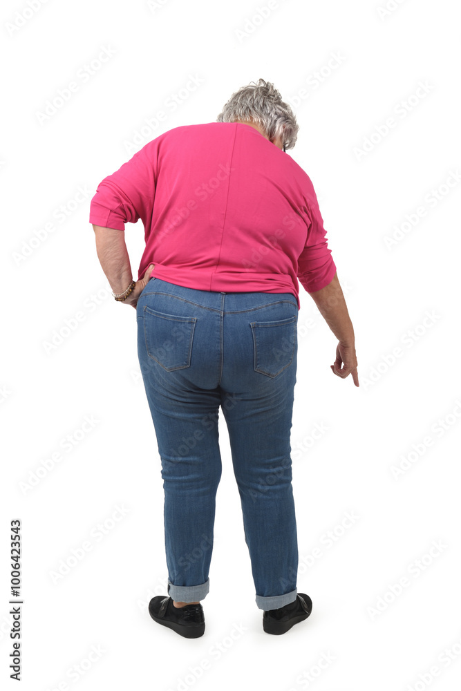 back view of a crouched senior woman looking at down and pointing finger at ground on white background