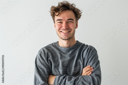 Young man with a cheerful expression and folded arms, white background , background blur