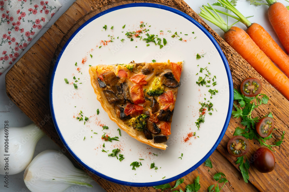 Piece of roasted vegetarian vegetable quiche. Top view table with decorations. Piece of roasted vegetarian vegetable quiche. Top view table with decorations.