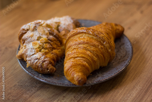 close-up of croissants stacked on wooden table.