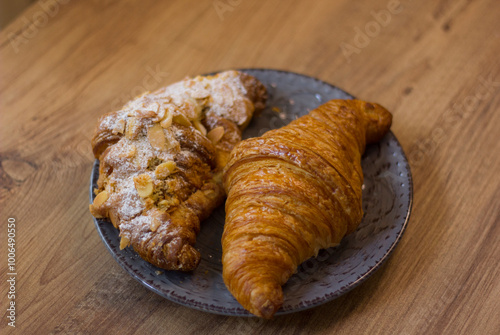 close-up of croissants stacked on wooden table.