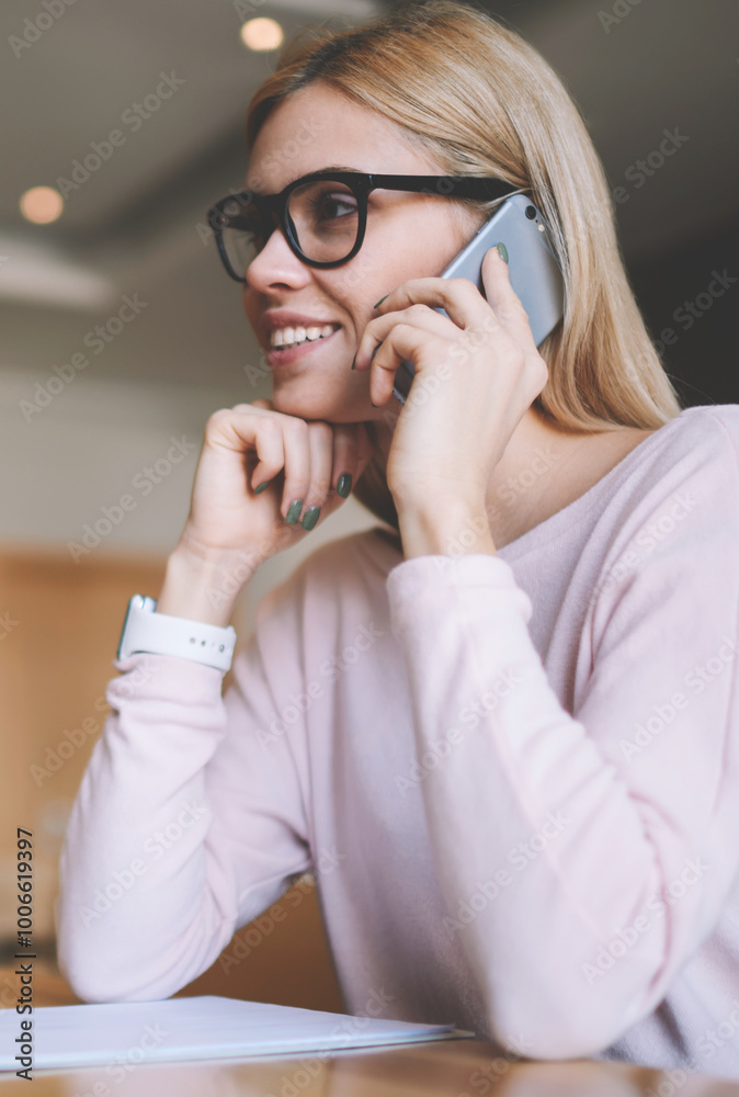 Happy female remote worker in spectacles for eye correction communicated with friend via smartphone application in break of distance job on modern netbook with blank screen for your content or website Happy female remote worker in spectacles for eye correction communicated with friend via smartphone application in break of distance job on modern netbook with blank screen for your content or website