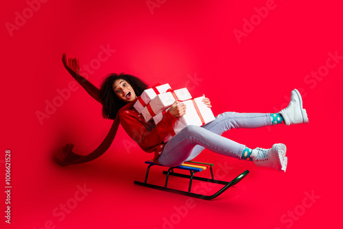 Photo of crazy excited girl riding sleigh xmas festive event giftbox preparation isolated on red color background