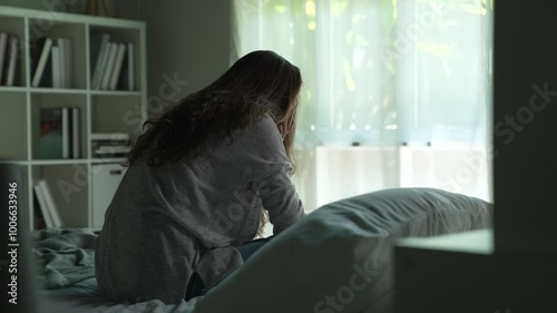 Young Asian woman sitting in a bedroom, feeling sad tired and worried suffering depression in mental health. in concept of depression anxiety and insomnia