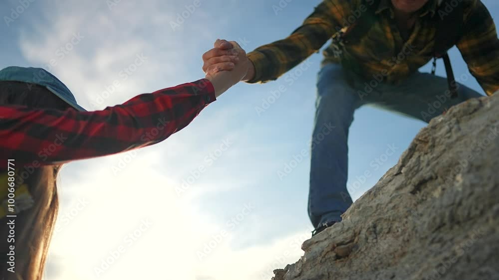 Family hiking on mountain. Man helps woman climb steep rock during outdoor travel adventure. Symbol family support help and teamwork. Travel success in nature through family help on mountain journey.