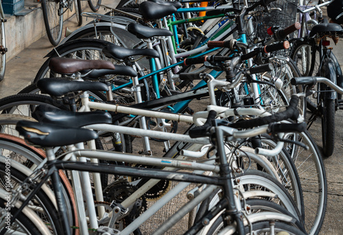 Obraz na płótnie Row of Bicycles parked in front of Second-hand bike Shop in bangkok. A lot of old bicycles different brand names parked on the street, Many second hand bikes for sale, Space for text, Selective focus. w salonie