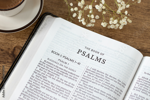 Psalms open holy bible book with coffee cup on wooden table. Studying and reading old testament Scripture, praising God Jesus Christ, Christian biblical concept.
