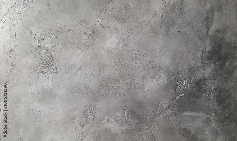 Naklejka premium A close-up shot of a textured grey concrete wall, with subtle light and dark variations creating an abstract pattern.
