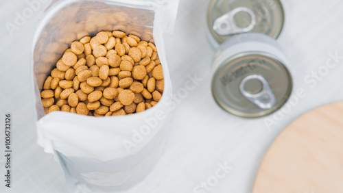 Pet Food Kibble and Cans on Light Surface