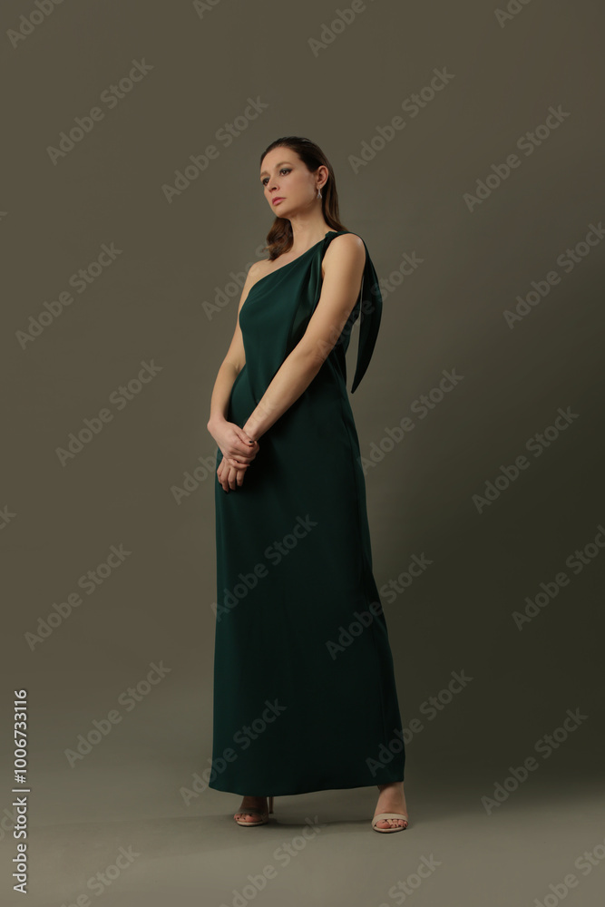 Fashion portrait of beautiful female model wearing elegant silk maxi one shoulder dress. Female gace and beauty, fashion and glamour concept. Fashion portrait of beautiful female model wearing elegant silk maxi one shoulder dress. Female gace and beauty, fashion and glamour concept.
