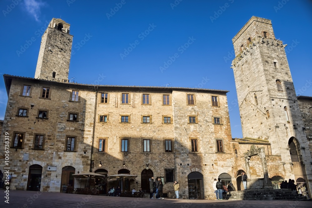 san gimignano, italien - 07.02.2024 - piazza della cisterna mit altem brunnen und geschlechtertürmen