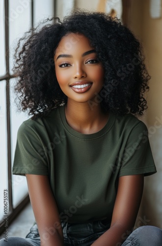  A army green t-shirt, worn by an African American woman model posing for brand photoshoots in her studio. 