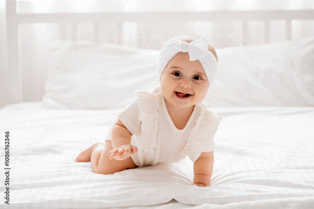 smiling baby girl laughing crawling on a bed in white clothes in smiling baby girl laughing crawling on a bed in white clothes in