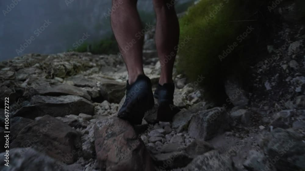 A close up of an athletic mans calves running across rocky terrain on a trail run in the darkness of the evening A close up of an athletic mans calves running across rocky terrain on a trail run in the darkness of the evening