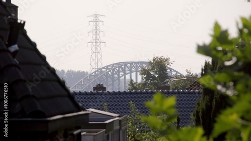 Oosterbeek's railway bridge framed by rooftops and an electricity pole in the foreground. Captured on a sunny day in Oosterbeek, Gelderland, Netherlands photo