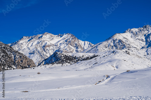 Winter landscape with mountains covered snow under a blue sky in cold sunny day