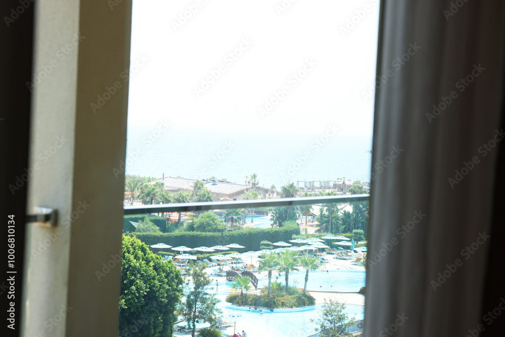 Fototapeta premium Beautiful view on luxury resort through glass window from hotel room