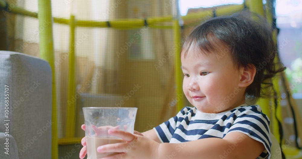Adorable Cute Toddler child enjoying Drinking Chocolate Milk from a glass sitting in a cozy home, Capturing a Sweet and Innocent Moment of Childhood Adorable Cute Toddler child enjoying Drinking Chocolate Milk from a glass sitting in a cozy home, Capturing a Sweet and Innocent Moment of Childhood