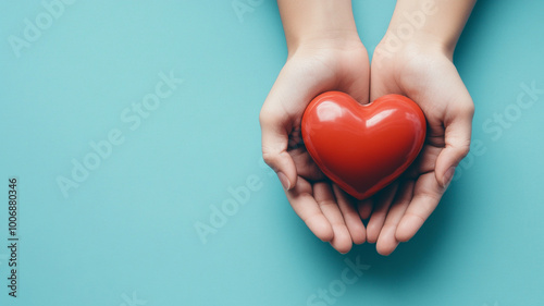 hands holding a red heart on a blue background. - a world heart day concept.