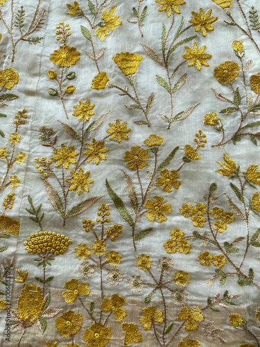 A delicate floral jaal is intricately hand-embroidered with fine yellow silk thread on luxurious white Chanderi silk.  photo