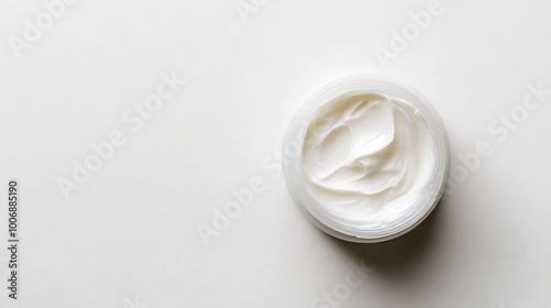 Close-up top view of a moisturizer sample in a jar. Shiny, smooth cream texture without any branding or logo. Clean, simple white background.