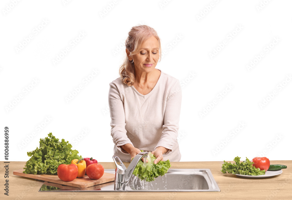 Woman washing vegetables in a kitchen sink and smiling Woman washing vegetables in a kitchen sink and smiling