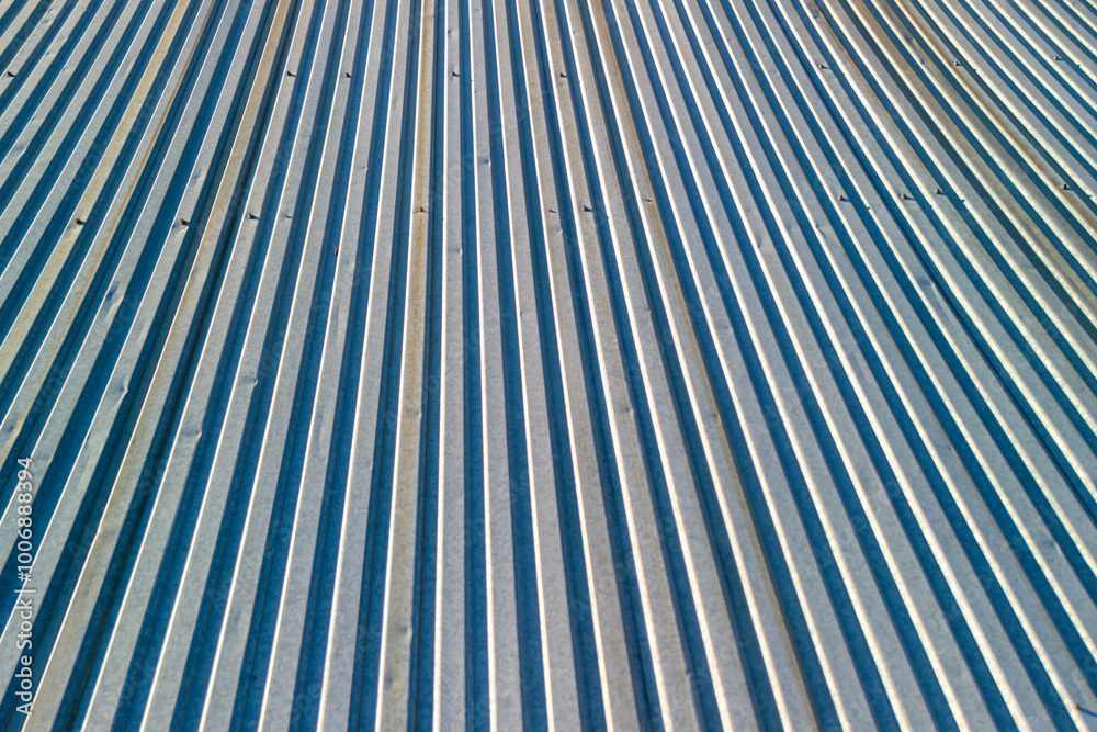 Fototapeta premium Close-up view of a textured metal surface showing parallel lines and shadows, conveying industrial aesthetics and modern design