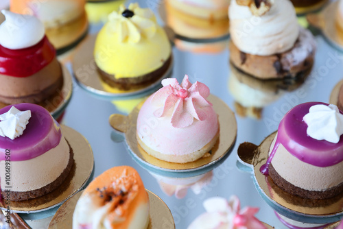 Different collored cakes filled with vanilla cream, strawberries, whipped cream, nuts placed on a plate. photo