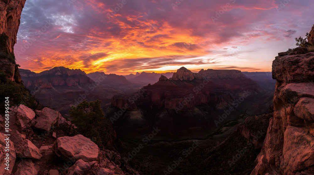 Fototapeta premium A stunning sunset paints the sky in vibrant hues of orange, pink, and purple above the dramatic landscape