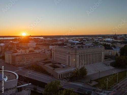 Cityscape of Helsinki's Töölö district, showcasing residential streets and buildings during a summer evening at sunset, with a view of the Finnish Parliament in the background photo