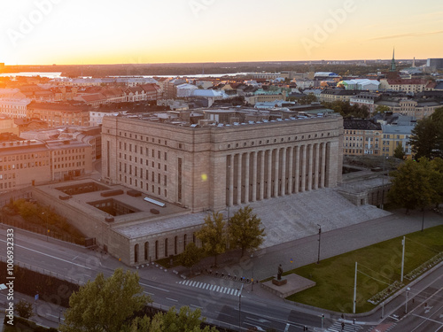 Cityscape of Helsinki's Töölö district, showcasing residential streets and buildings during a summer evening at sunset, with a view of the Finnish Parliament in the background photo