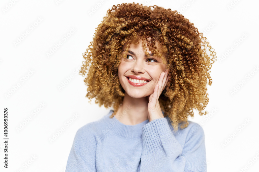 Smiling woman with curly hair expressing joy and positivity, wearing a light blue sweater against a clean white background Her cheerful demeanor conveys happiness and confidence Smiling woman with curly hair expressing joy and positivity, wearing a light blue sweater against a clean white background Her cheerful demeanor conveys happiness and confidence