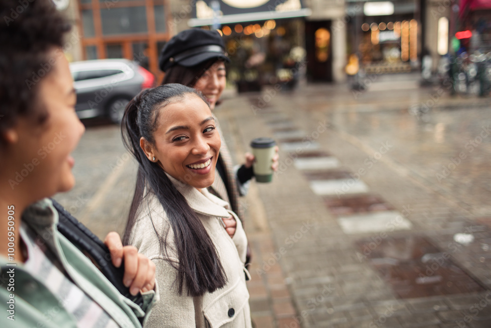 Three diverse female friends walking together on city street Three diverse female friends walking together on city street