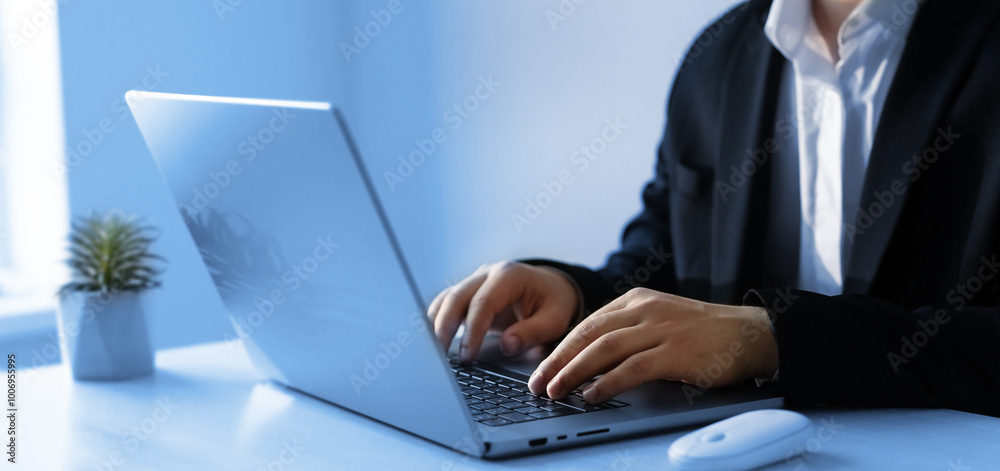 Businessman working on laptop in a modern office.Businessman in a suit typing on laptop keyboard. Businessman working on laptop in a modern office.Businessman in a suit typing on laptop keyboard.