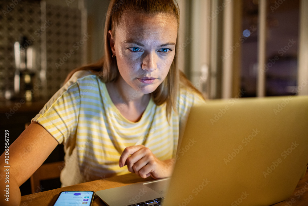 Woman stressed while working on laptop late at night Woman stressed while working on laptop late at night