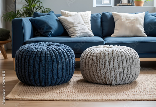 Two knitted poufs near dark blue corner sofa. Scandinavian home interior design of modern living room.