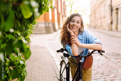 Happy woman riding bicycle at the city street outdoor. Freedom on two wheels. Active lifestyle.