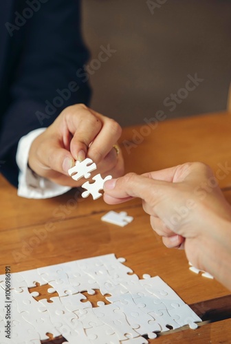 Collaborate between Professional Businessman and Partnership. Group of Business people holding piece of jigsaw puzzle to solution problem during brainstorming meeting -vertical image.