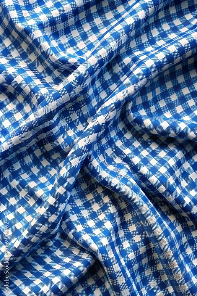 Textured blue and white checkered fabric draped artistically under soft light creating a cozy atmosphere for crafts. Generative AI