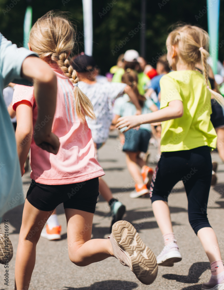 Fototapeta premium Children marathon runners crowd, young teen sportsmen participants start running in the city streets, crowd of kids joggers in motion, kid group athletes outdoor run, family competition in summer day