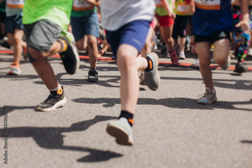 Children marathon runners crowd, young teen sportsmen participants start running in the city streets, crowd of kids joggers in motion, kid group athletes outdoor run, family competition in summer day Children marathon runners crowd, young teen sportsmen participants start running in the city streets, crowd of kids joggers in motion, kid group athletes outdoor run, family competition in summer day