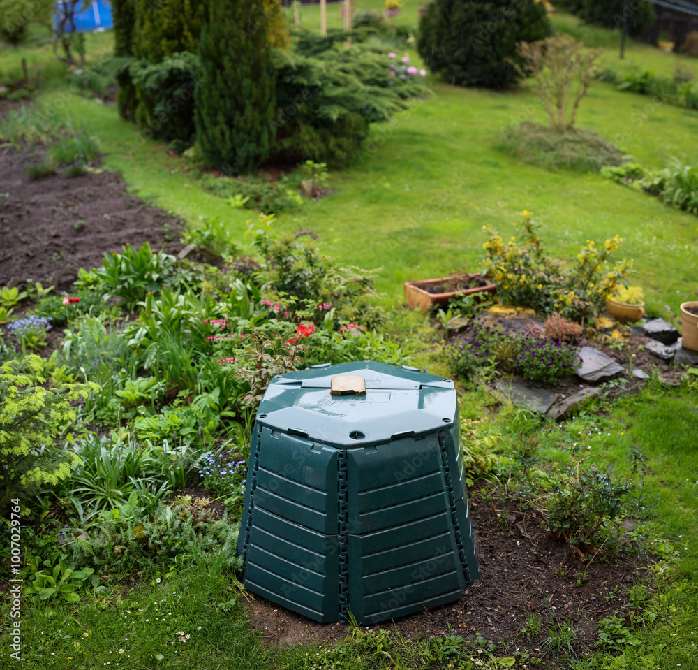 Outdoor composting bin for recycling kitchen and garden organic waste in a lovely lush garden