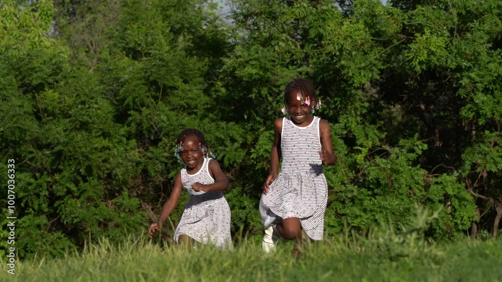 Two black-skinned sisters playing at sunset in the park Two black-skinned sisters playing at sunset in the park